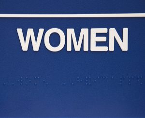 Women's restroom sign with Braille to illustrate Why ADA-Compliant Signage Matters for Your Business.